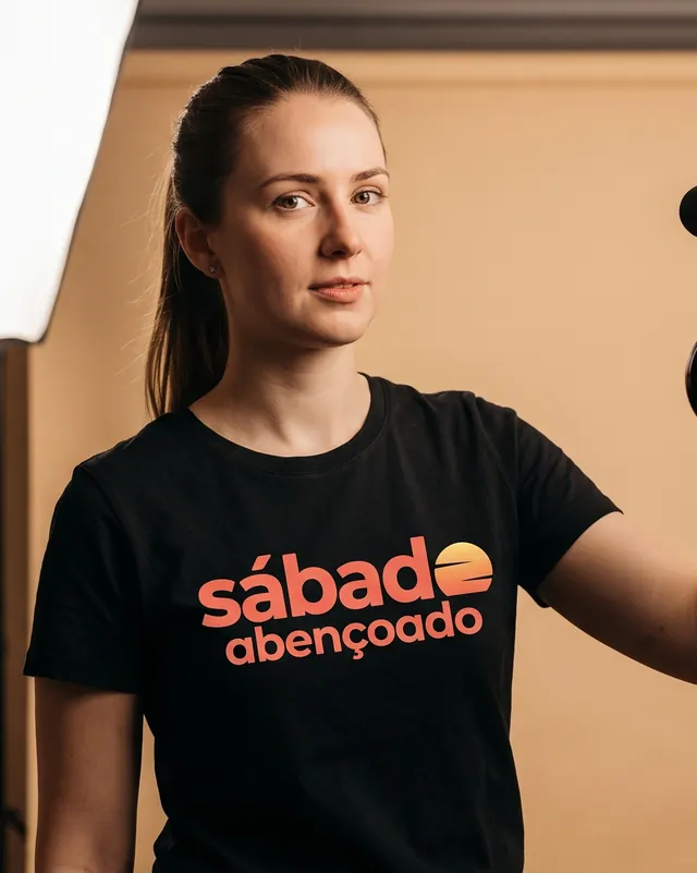 Integrante da equipe com camiseta preta e o logo na versão principal
